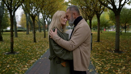 Fototapeta premium Beautiful lovers standing together facing each other in romantic autumn park.