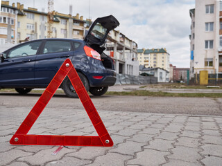 Emergency stop sign on the background of the car with the alarm system on.