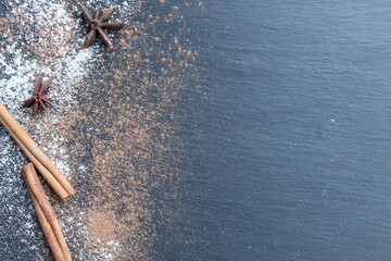 Eating background icing sugar cocoa cinnamon and badyan on a black dark gray background with a...