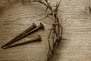 Crown of thorns with three nails on wooden background. Easter concept.