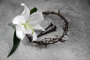 Good Friday, Passion of Jesus Christ. Crown of thorns, nails and white lily on grey background. Christian Easter holiday.