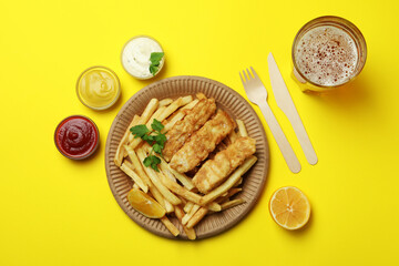 Concept of tasty eating with fried fish and chips on yellow background