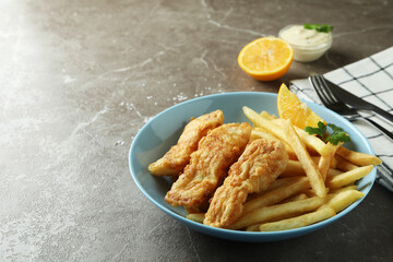 Concept of tasty eating with fried fish and chips on gray textured table
