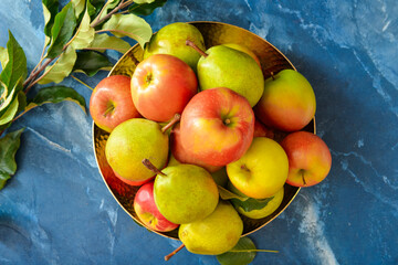 Plate with tasty apple and pear fruits on color background