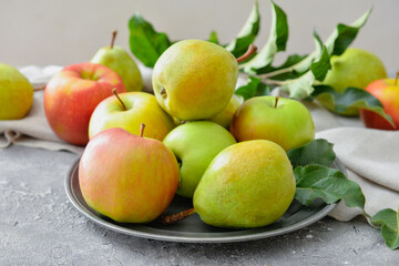 Plate with tasty apple and pear fruits on grey background
