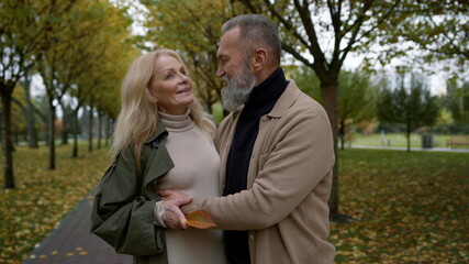 Fototapeta premium Happy couple hugging in autumn park. Close up romantic lovers talking.