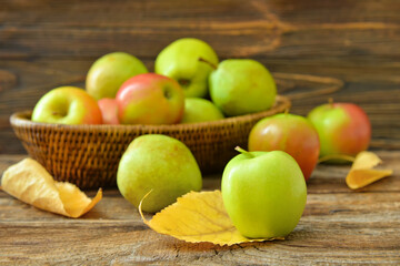 Basket with tasty apple and pear fruits on wooden background
