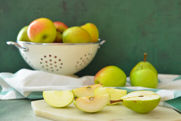 Board with tasty apple and pear fruits on color background