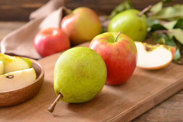 Board with tasty apple and pear fruits on table