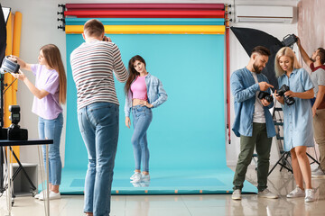 Obraz premium Young photographer taking picture of woman in studio
