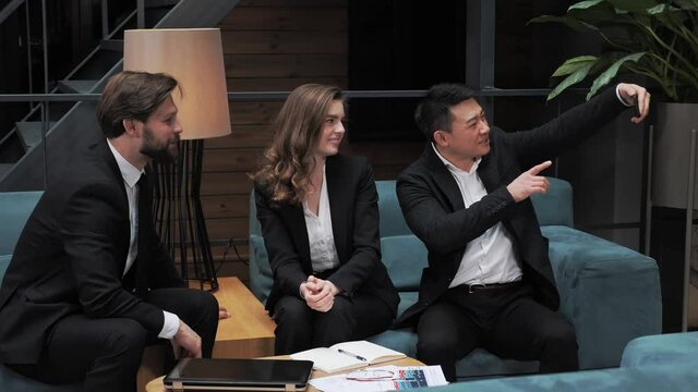 Stylish diverse businessmen in a classic suits having video call chat conferencing with business partners or boss in a modern office building Business. Social Networking. People. Apps.