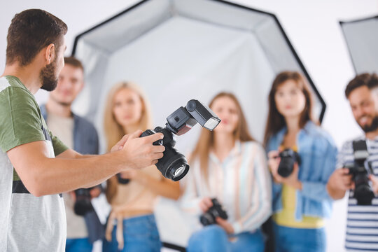Mentor teaching young photographers in studio