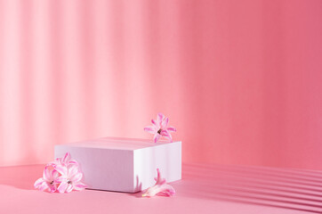 White square podium for presentation cosmetic, accessories and produce on sunny bright pastel pink...