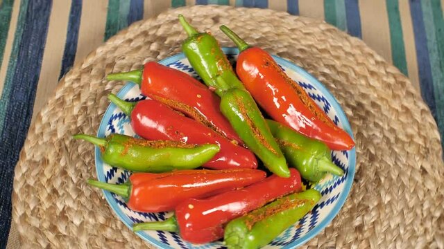 Homemade red and green chilies pickle / Mirchi ka Achaar / Loncha on a jute mat. Closeup shot of Indian spicy Masala Mirchi Achaar placed beautifully on a colorful plate
