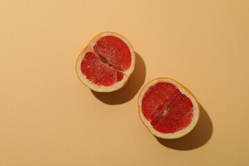 Grapefruit halves on beige background, top view
