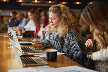 Charming young woman working on project with colleagues
