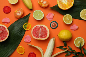 Sex concept with fruits and condoms on orange background