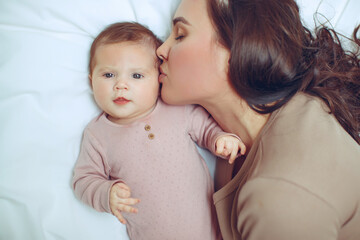 A young mother is holding her newborn baby. Mother of a nursing baby. Mother breastfeeding her baby. The family is at home. Portrait of a happy mother and child. High quality photo.