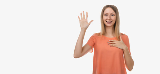 Portrait of sincere blond girl raising one arm and hold hand on heart as give oath, telling truth,...