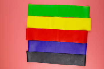 Set of elastic rubber bands for fitness on a pink background. Top view
