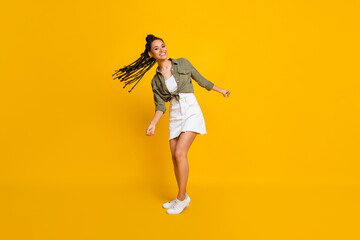 Fototapeta na wymiar Full length photo portrait of cute girl swinging hair isolated on vivid yellow colored background