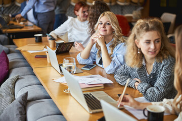 Beautiful young woman working on business project with colleagues