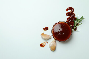 Bowl of barbecue sauce and spices on white background
