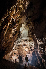 Spelunkers exploring a gigantic monumental cave hall