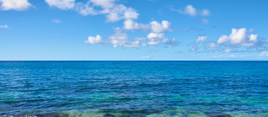 Panoramic view of the blue sky with rare clouds over ocean surface in Hawaii.