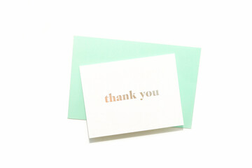 Thank you card on pastel green envelope on white background. Simple minimalist composition. Special thank you note.	