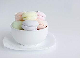 Marshmallows, zephyr - confectionery and sweets isolated on a gray background, on a white plate. Template, layout, blank. Copy space. Selective focus.