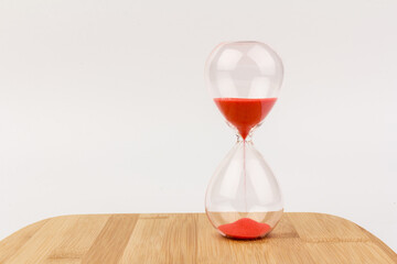 Crystal hourglass on wooden background as a concept of passing time for business term, urgency and outcome of time.