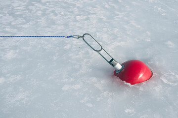Red buoy in frozen harbor in early springtime, Finland