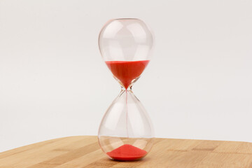 Crystal hourglass on wooden background as a concept of passing time for business term, urgency and...