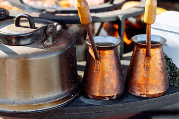 two copper Turks are warming themselves with coffee on the street cafe