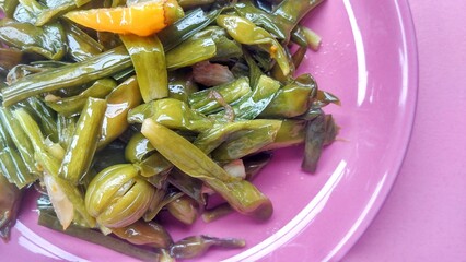 Coocking vegetable Limnocharis flava, which is cooked with a mixture of onions, garlic, chilies and coconut oil. Served on a pink ceramic plate