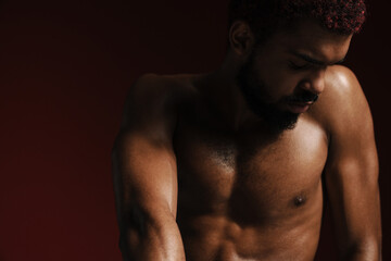 Fototapeta premium Black shirtless bearded man posing and looking downward