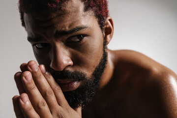 Black shirtless bearded man posing and looking aside