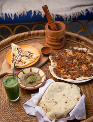 Middle eastern or arabic dishes and assorted meze: hummus, pita, Manakish Lahm Bi Ajeen - Flatbreads topped with minced meat and Fatayer stuffed pie. Halal food