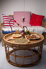 Middle eastern or arabic dishes, assorted meze and hookah on table: pita, Manakish Lahm Bi Ajeen - Flatbreads topped with minced meat, Fatayer stuffed pie and Manakish Zaatar.