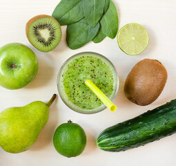 Fresh green smoothie in the glass and fruits and vegetables