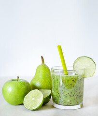 green smoothie in a glass with lime, pear and apple