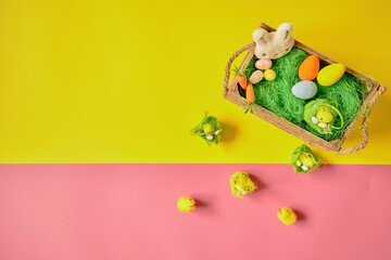 Easter eggs on the yellow -pink background. Happy Easter. Holiday concept. Focus on chicken on yellow background.