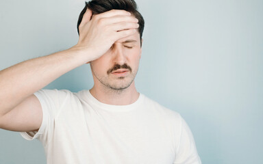 Man holding his forehead indoors, close-up. Headache, disorder, depression, fatigue concept