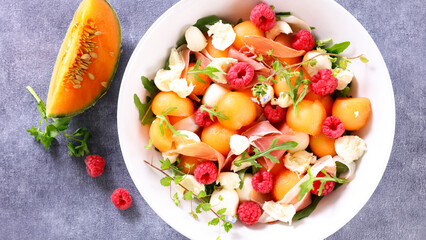 melon salad with mozzarella,  ham and raspberry