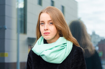 portrait of pensive redhead ginger girl with freckles and blue eyes outdoors.