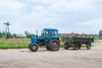  Tractor Belarus with a trailer rides on the road. 