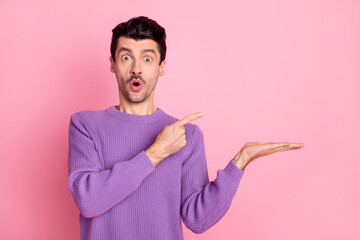 Photo of young man amazed shocked indicate finger product promo offer advert isolated over pink color background