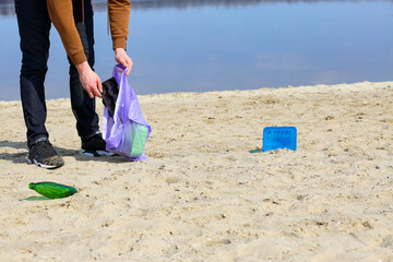 Cleaning the beach from plastic and debris.Collects garbage on the beach.Garbage collection in nature.Save the earth from debris.Save the planet from plastic.Environmental Protection. Graze the ocean 