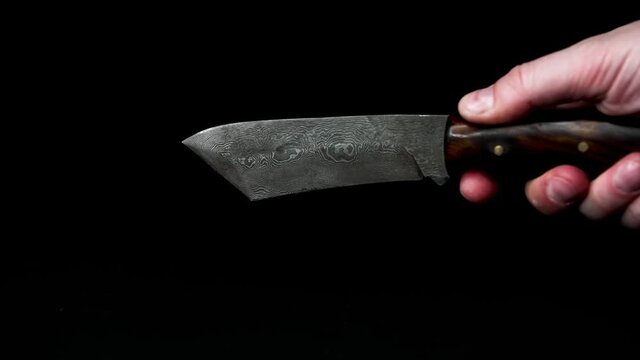 self forged damascus steel knife against black background